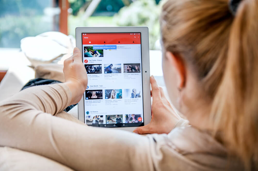 mulher com tablet em maos na pagina inicial do youtube