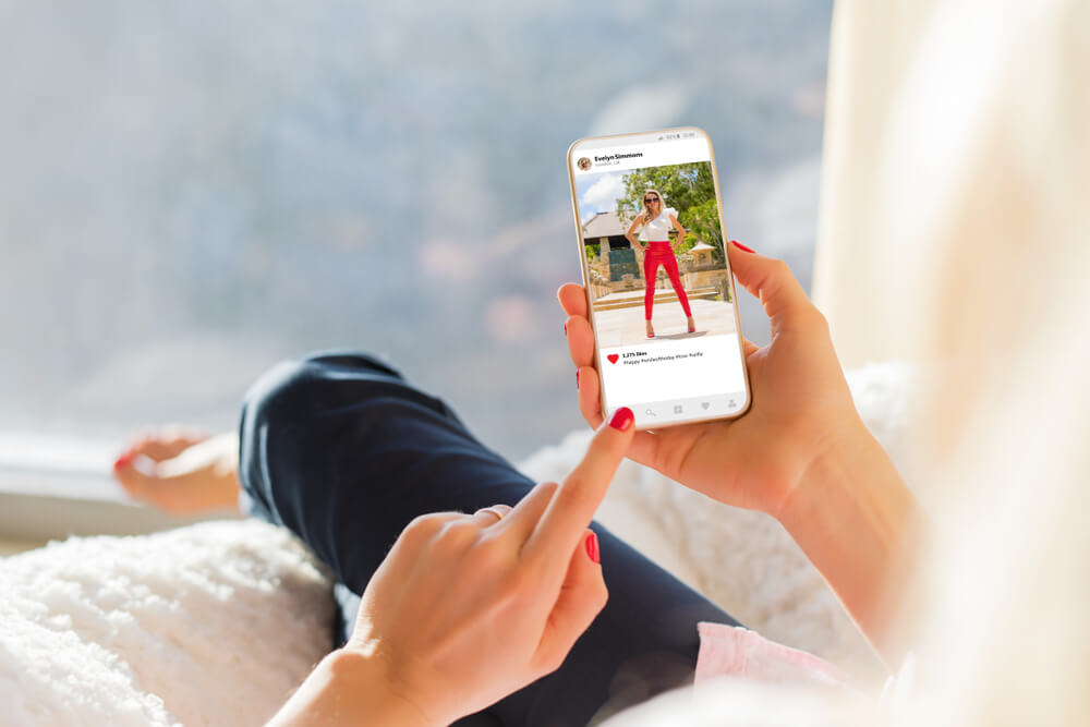 mao feminina segurando smartphone em postagem no aplicativo instagram