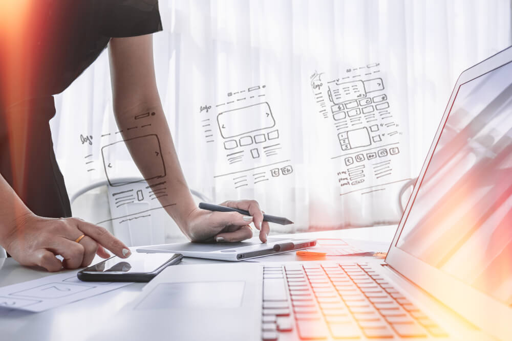 mão masculina em frente a laptop e ilustrações sobre identidade web de marca