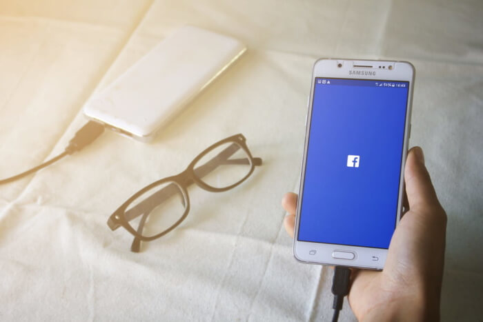 smartphone acessando facebook junto de óculos