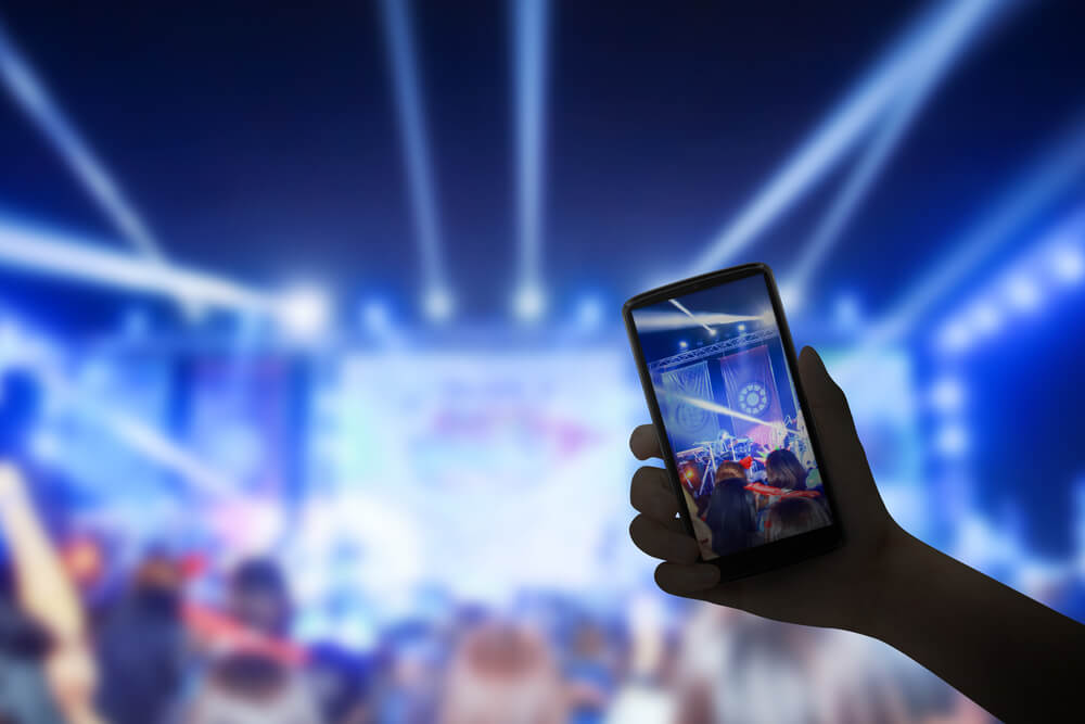 smartphone em transmissão de show musical pela ferramenta live do facebook