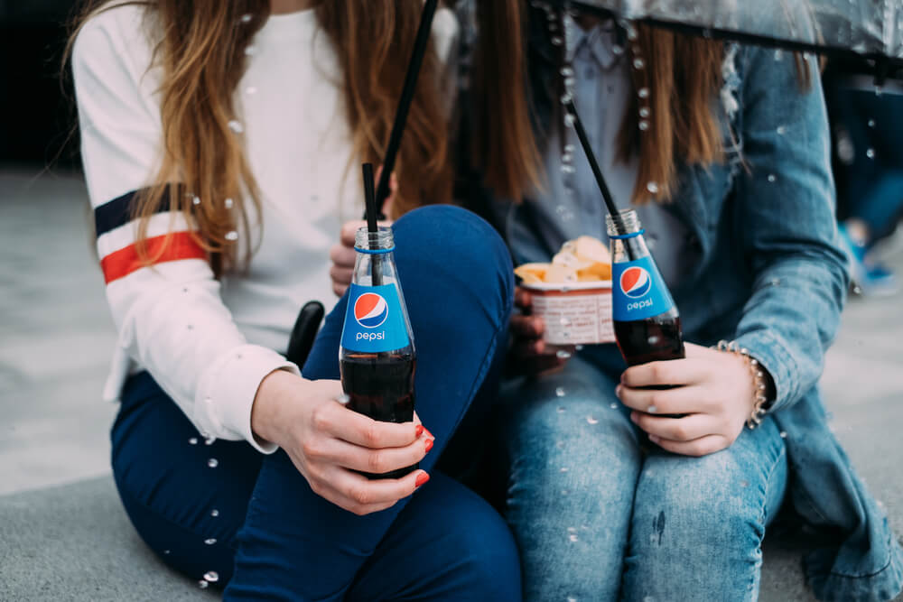 dupla de garotas com garrafas do refrigerante Pepsi
