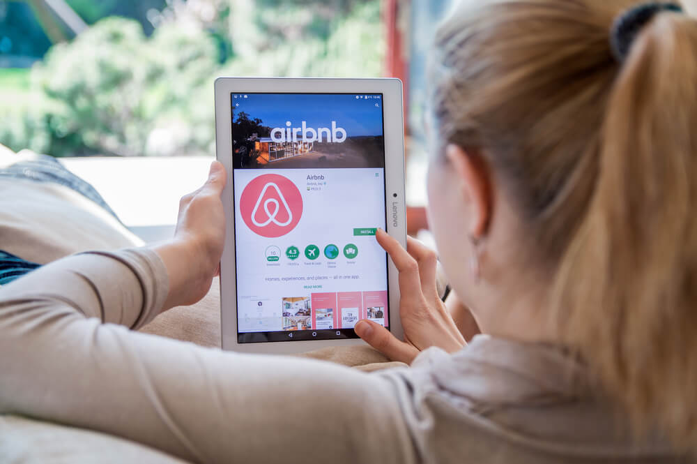 garota acessando o download do aplicativo mobile AirBnb