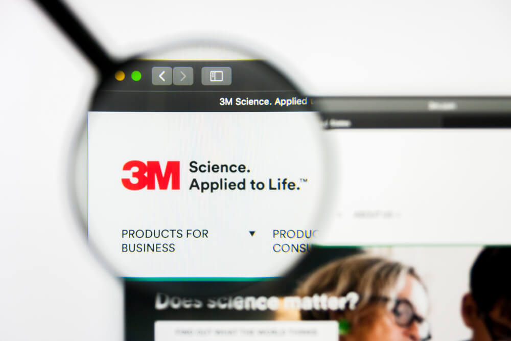 lupa em tela de laptop destacando a logomarca da empresa 3M em página inciial web para desktop