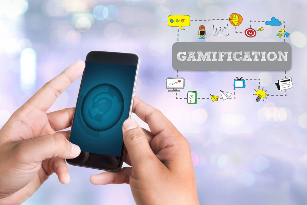 mão masculina acessando smartphone e ilustração de título gamificação e símbolos relacionados