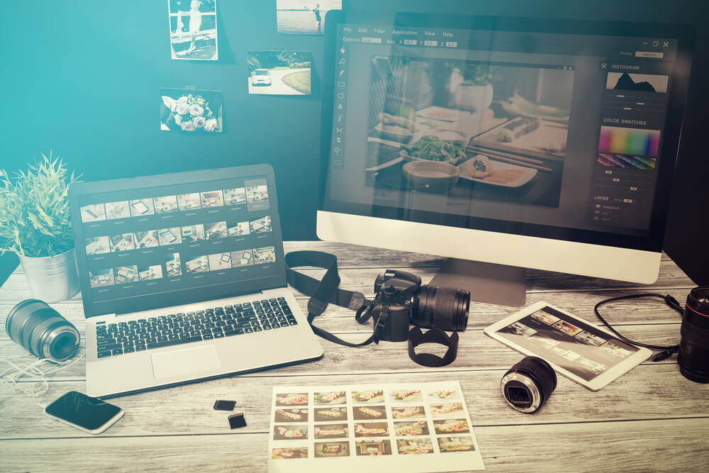 mesa de profissional da fotografia e tela de desktop acessando banco de imagens