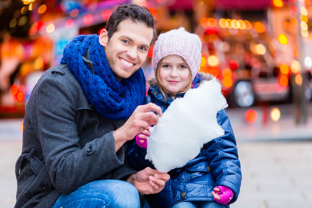pai e filha consumindo algodão doce em centro de publicidade infantil