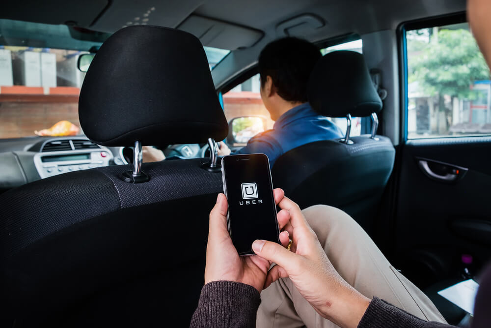 passageiro em carro com smartphone em maos no aplicativo uber