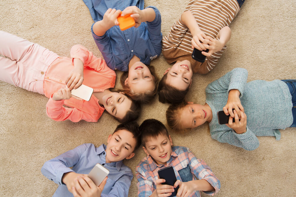 roda de crianças acessando smartphones