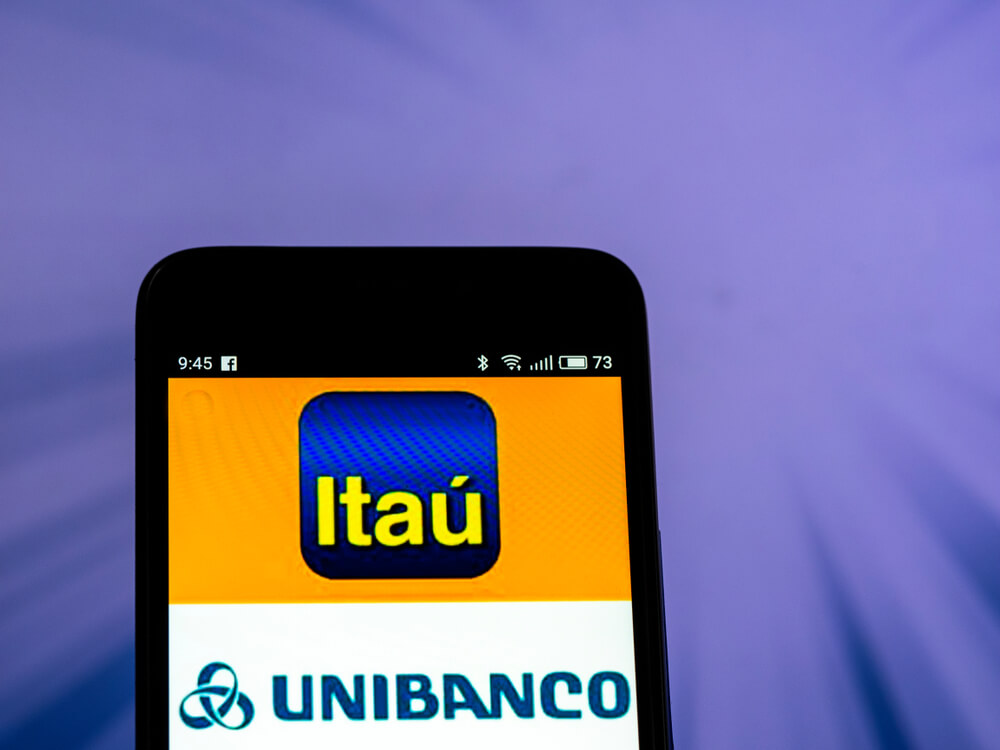 tela de smartphone com imagens de logo das empresas Itaú e Unibanco