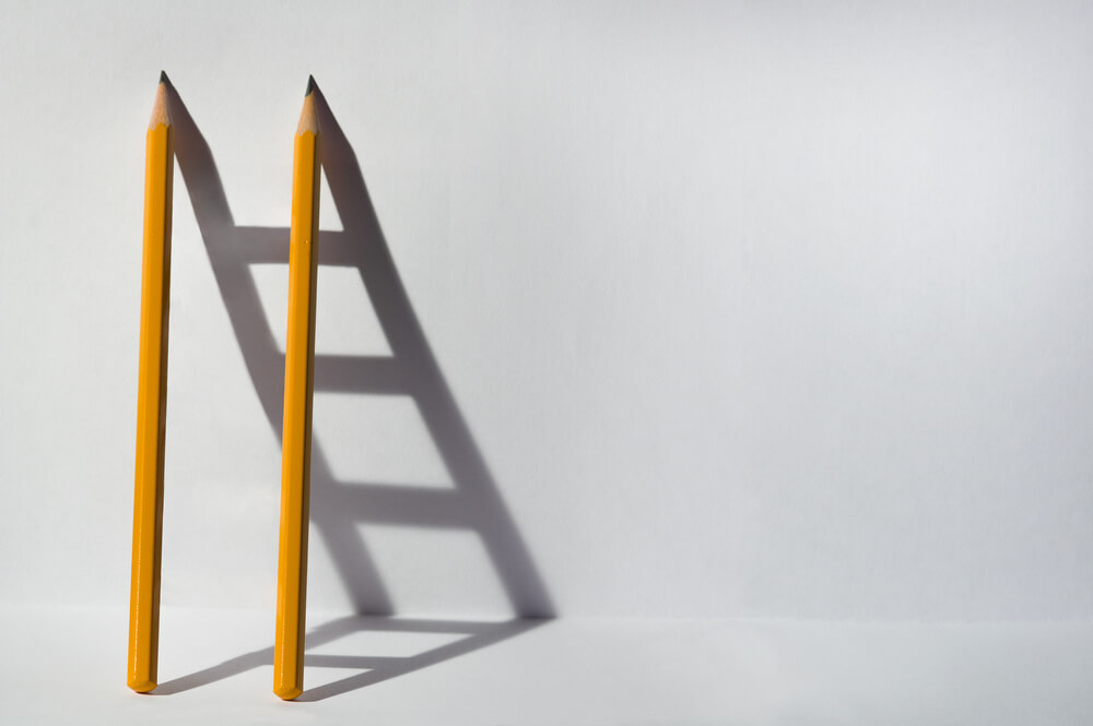 lápis e sombra de escada representando resoução de problemas no processo de white paper