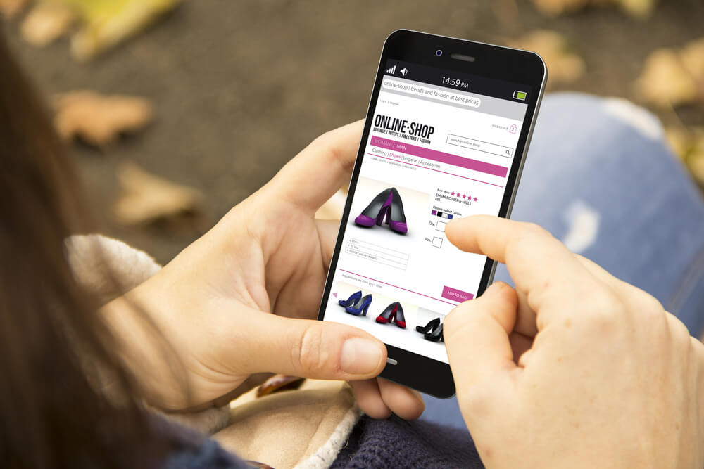 consumidora virtual segurando smartphone em site de compras online