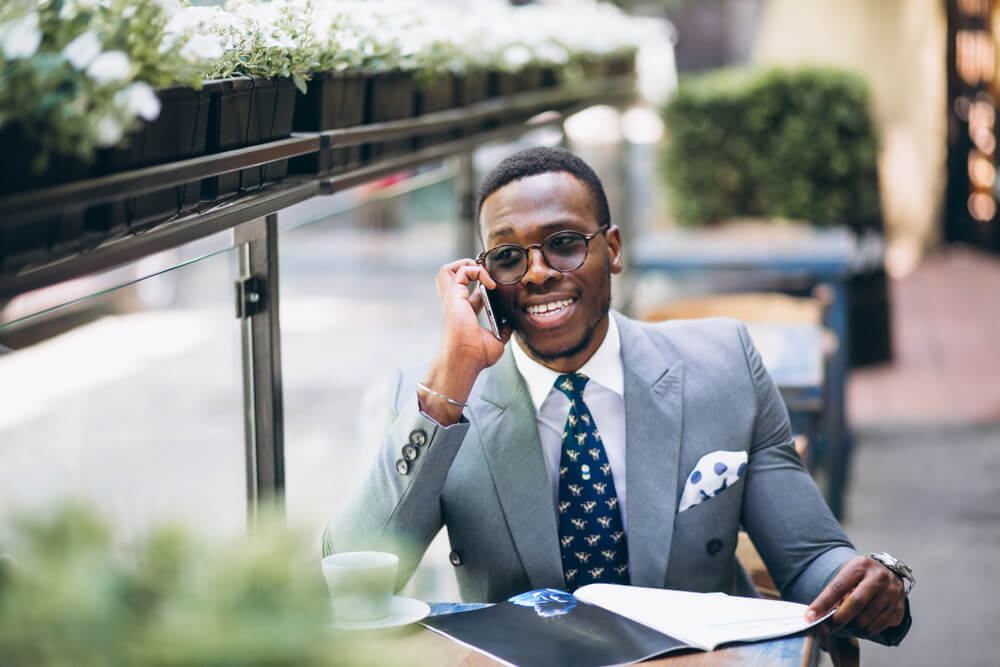 homem executivo sorrindo ao efetuar venda bem sucedida por telefone