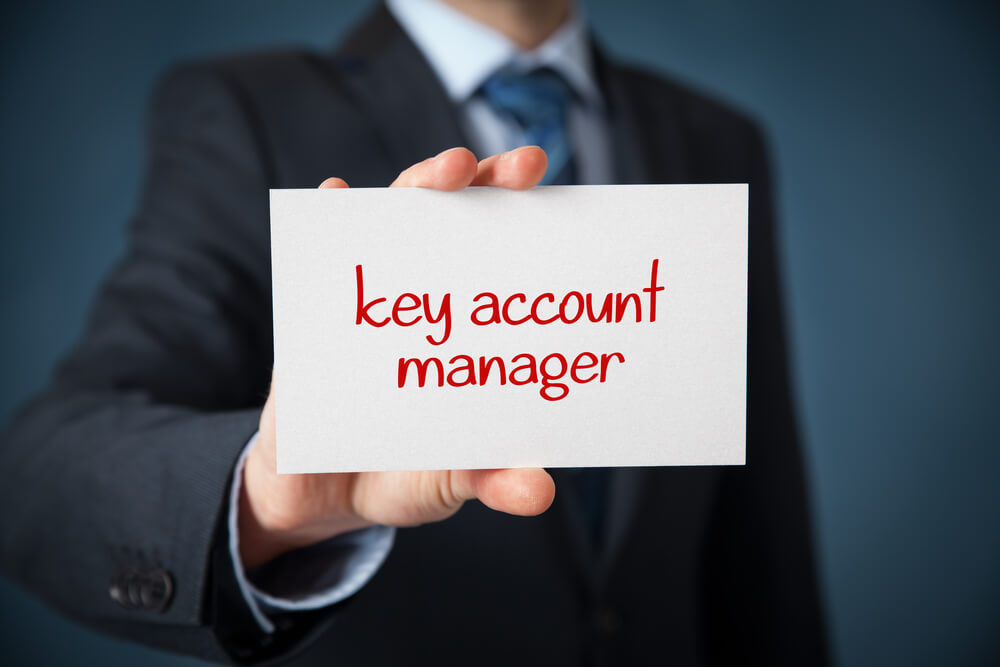 profissional segurando placa entitulada key account manager
