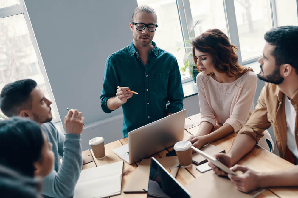 equipe reunida em mesa analisando plano de marketing pessoal