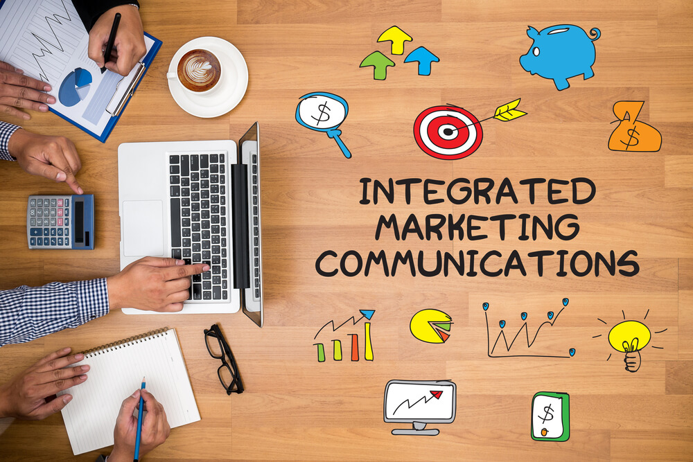 visão superior de mesa de trabalho com título comunicação integrada de marketing